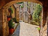 Arched cobblestone street in a Tuscan village, Italy 