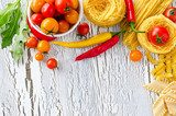Mix of pasta, tomatoes and chili copy space wooden background 