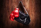 Sports bag and boxing gloves hanging on a wall 