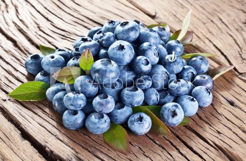 Blueberries over old wooden table.