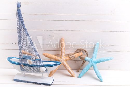 Decorative sailing ship and marine items on wooden background.