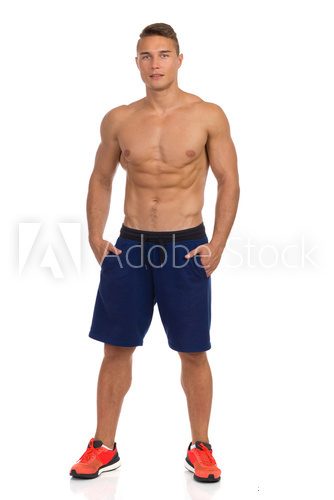 Fit Young Man In Shorts Posing With Hands In Pockets