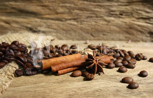 Roasted coffee beans  and spices on grunge wooden board  backgro