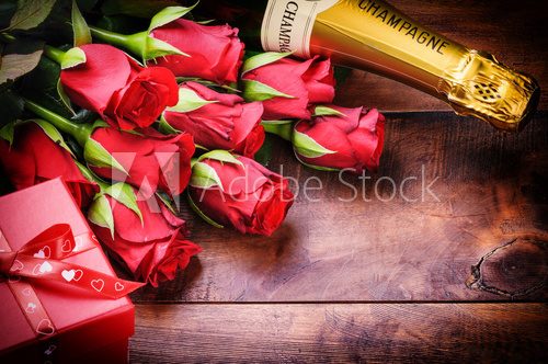 Valentine's setting with red roses, champagne and gift