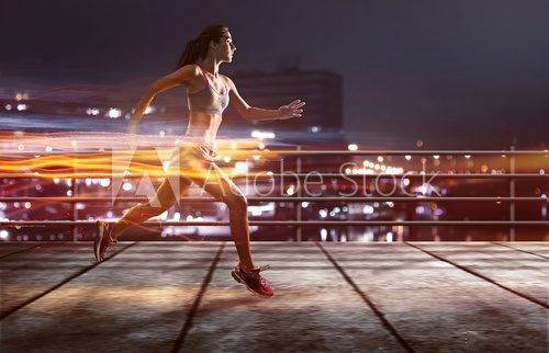 Läuferin joggt vor beleuchteter Stadt