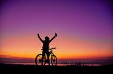 Girl with a bicycle watching the sunset