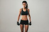 Strong woman with weights and confident expression