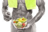 Bodybuilder holding a bowl of fresh salad, isolated on white bac