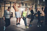 Adults doing chin ups for cross fit training