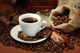 cup of coffee and coffee beans on brown background 