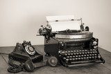Vintage phone, old typewriter on table desaturated photo 