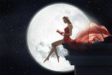 Cute woman over full moon background 