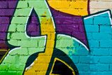 Graffity: Colorful detail on a textured brick wall 