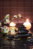 fiori di mandorla con candele e pietre nere 