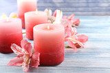 Beautiful candles with flowers on wooden background 