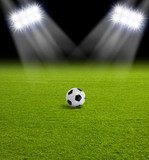Nocny stadion z piłką na zielonej trawie