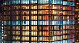 Wieżowiec nocą pełen świetlnych refleksów