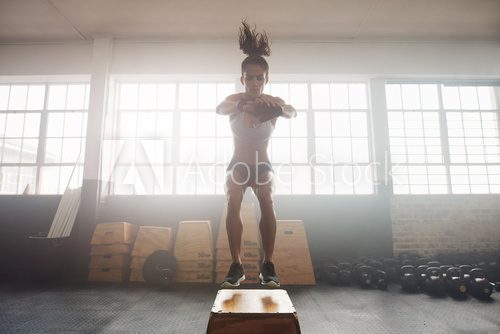 Young woman working out with a box at the gym