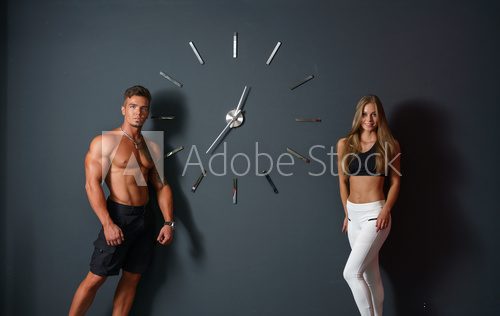 Sport time. Concept. Athletes posing with clock