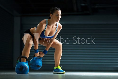 Young fit woman has cross fit training by kettle bell.