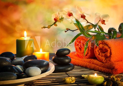 preparation for massage in orange lights and black stones