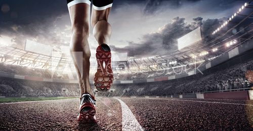 Sports background. Runner feet running on stadium closeup on shoe. Dramatic picture.