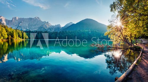 Colorful summer view of Fusine lake. Bright morning scene of Julian Alps with Mangart peak on background, Province of Udine, Italy, Europe. Traveling concept background.