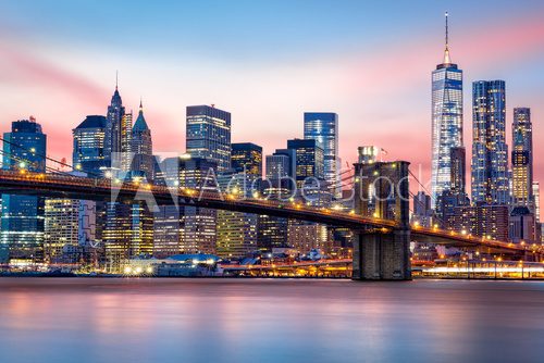 Brooklyn Bridge at and the Lower Manhattan skyline under a purple sunset