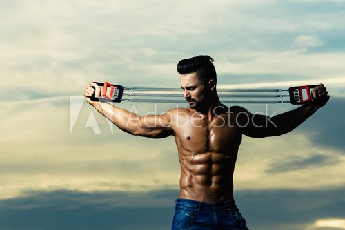 workout of man with muscular body workout with expander gripper