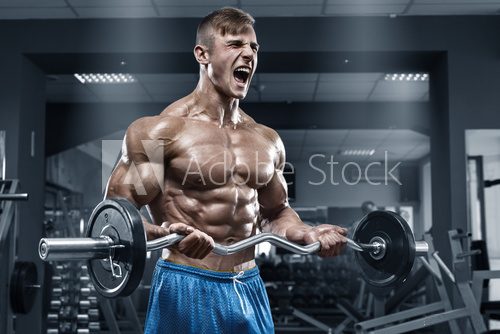 Muscular man working out in gym doing exercises, strong male naked torso abs