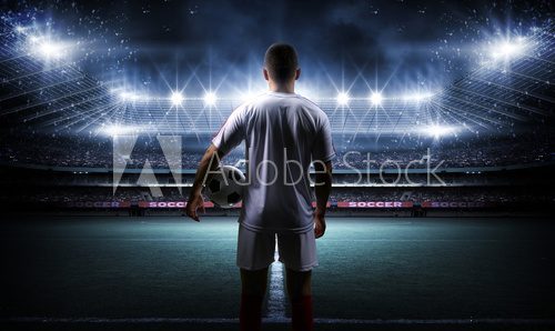 Football player with ball on field of stadium